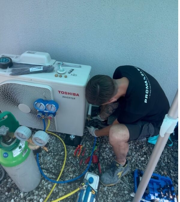 Technicien de Promaxelec sur un groupe extérieur de climatisation Toshiba à Chirens (38)